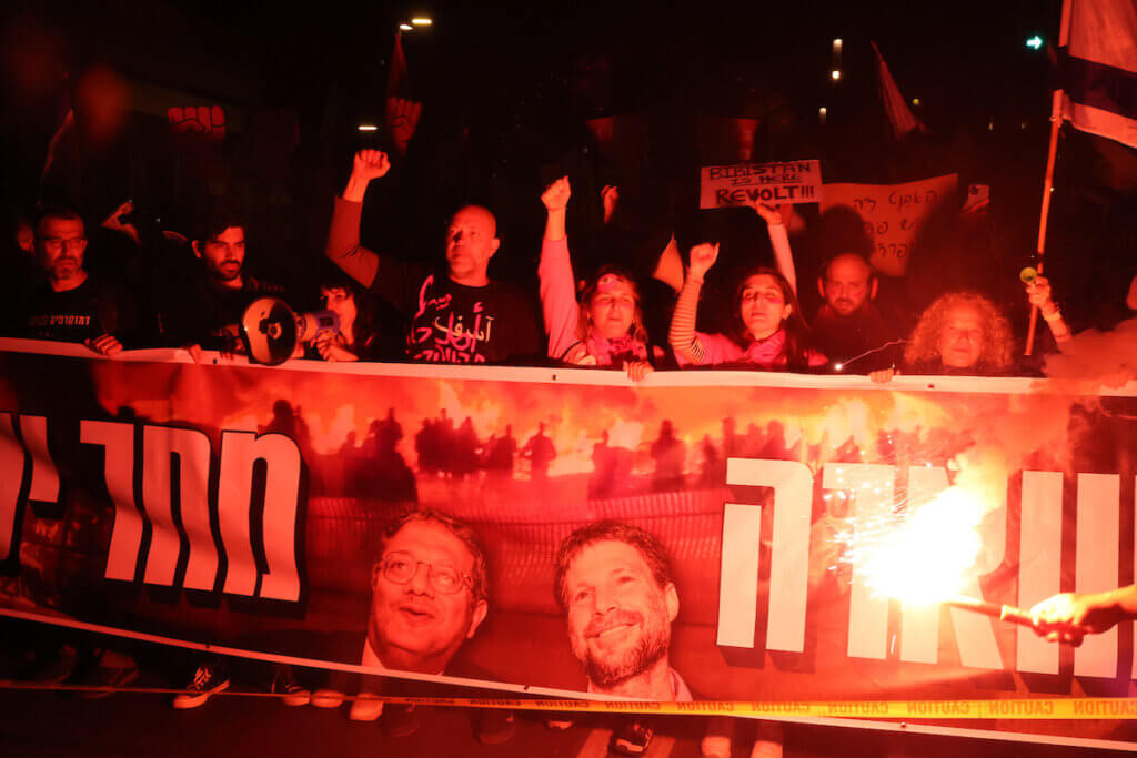 Israeli protesters in Tel Aviv hold a banner and burn flares during a demonstration against the Israeli government, March 4, 2023. (Credit Image: Ilia Yefimovich/dpa via ZUMA Press)