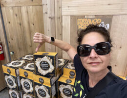 Activist Estee Chandler flashes the thumbs down gesture in a selfie photo in front of a display of Israeli motzo at Trader Joe's.