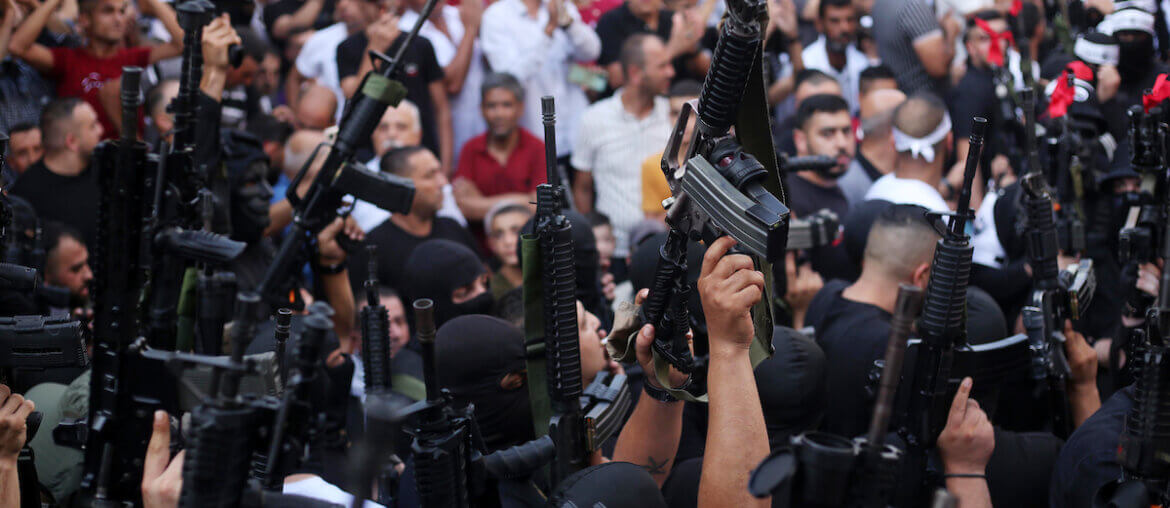 Members of the Palestinian resistance hold their weapons during a memorial service for Mohammed al-Azizi and Abdul Rahman Sobh, who were killed by Israeli forces in July 2022, in the West Bank city of Nablus. (Photo: Shadi Jarar'ah/APA Images)