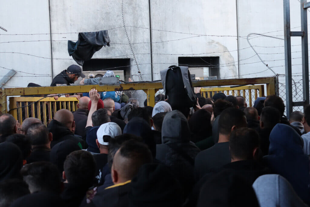 Thousands of Palestinian workers cross the Israeli Eyal checkpoint in Qalqilya, West Bank, on their daily trip to workplaces in Israeli settlements and Palestinian towns behind the Israeli colonial wall, in March 2023. (Photo: Ahmad Al-Bazz, Activestills)