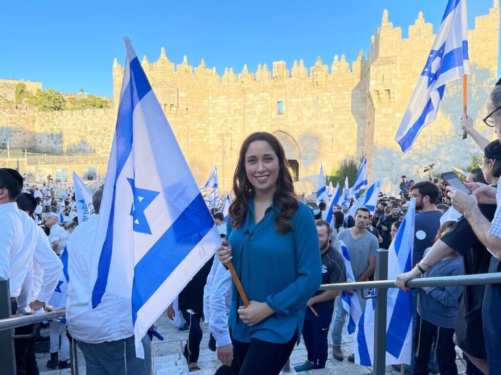 Knesset Member May Golan holding an Israeli flag at a settler "Flag March" in Jerusalem, standing in front of Jerusalem's Damascus Gate.