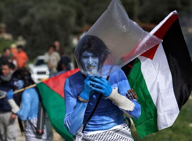 A protester dressed as a Na'vi inhabitant of Pandora uses a plastic bag to avoid tear gas fired by Israeli border police during a protest in Bilin (Photo: Reuters)