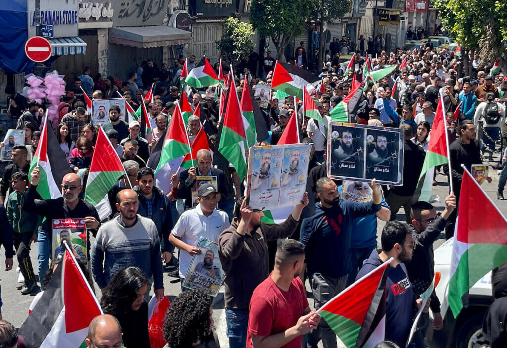 Palestinian protesters in al-Manarah Square in downtown Ramallah, holding Palestinian flags and posters of the slain Khader Adnan after the annuncement that the 44-year-old hunger striker died in Israeli custody after 86 days on hunger strike protesting his imprisonment.