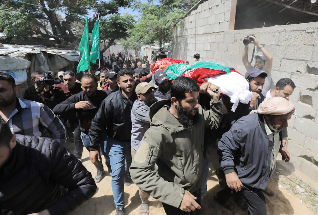 Palestinian mourners carry the body of Hashel Mubarak over their shoulders as they walk through the tight alleyways of Beit Lahiya.