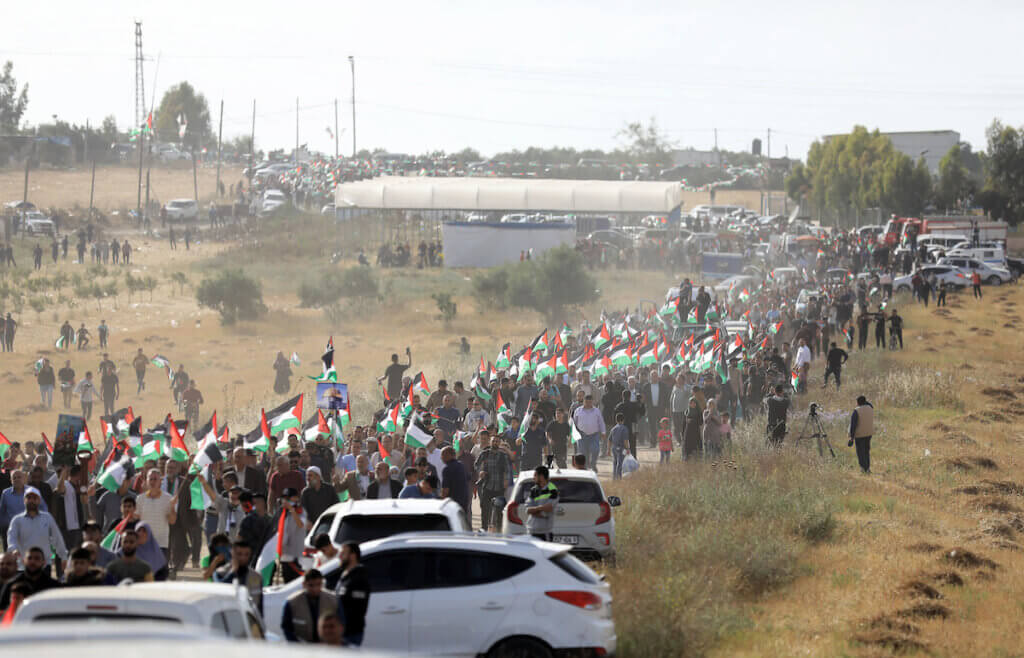 A stream of Palestinian protesters holding Palestinian flags gather during a Palestinian 