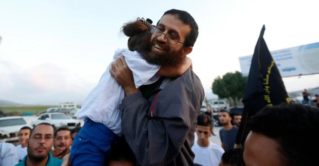 Khader Adnan holding his daughter whose arms are wrapped around him as he is arriving in his hometown of Arrabeh near Jenin, after release from Israeli prison in July 2015.