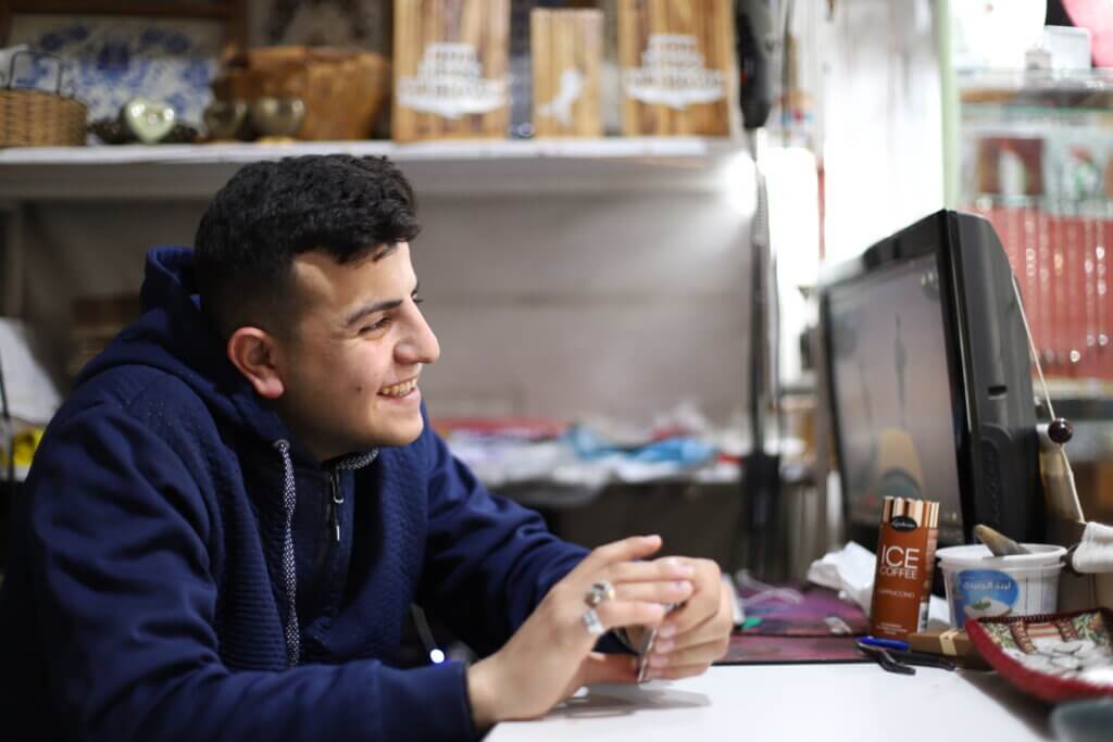 Abdelrahman "Abood" al-Waara, 20, spends his days working at his family's souvenir shop. Abood says that if his family was never kicked out of their home and made refugees, he might have been a farmer, or dreamed of something other than freedom. (Malik Hamamra/Mondoweiss) Aida Refugee Camp, occupied West Bank, May 2023.