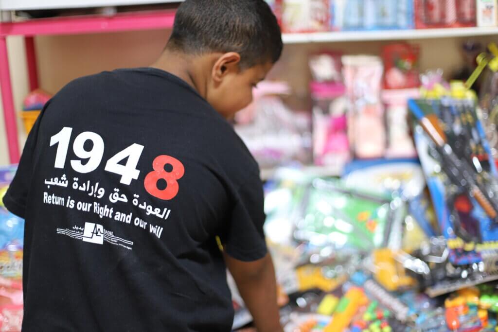 A Palestinian boy wears a t-shirt that ready "1948 - Return is our right and our will". (Malik Hamamra/Mondoweiss) Aida refugee camp, occupied West Bank, May 2023.
