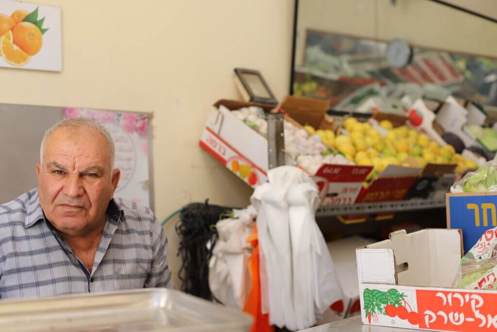 Mohammad al-Amir sits in his family's vegetable store in the Aida refugee camp. (Malik Hamamra/Mondoweiss) Aida refugee camp, occupied West Bank, May 2023.