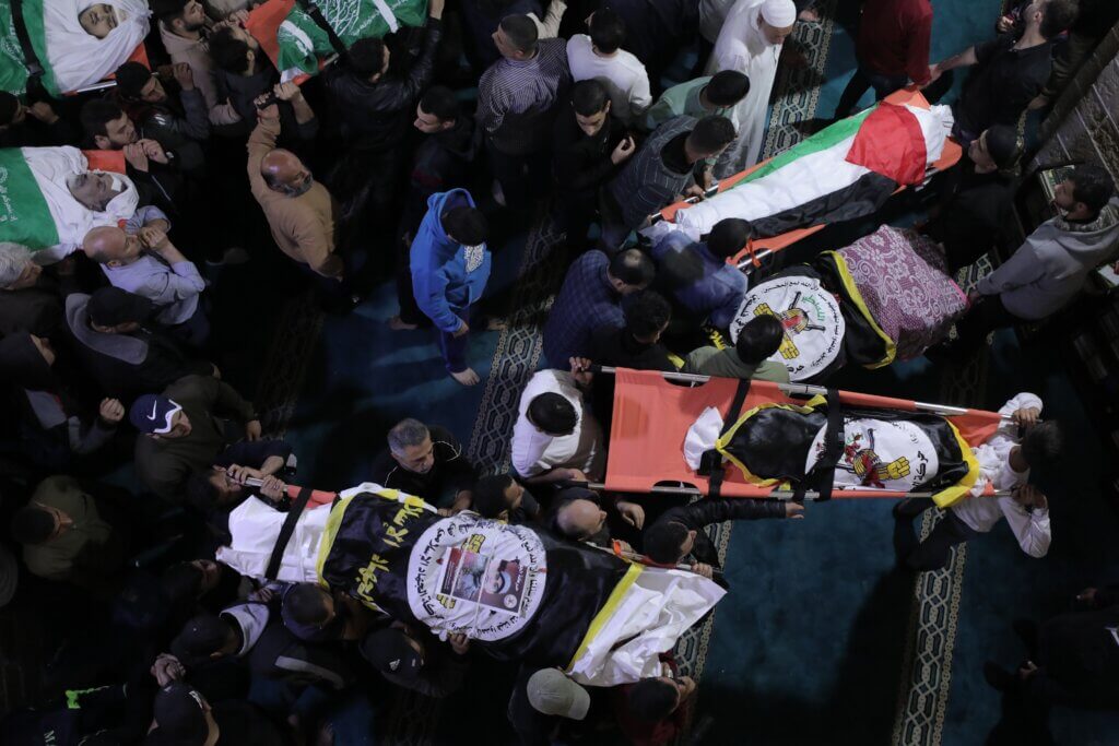 An overhead shot from the funeral of the 12 Palestinian martyrs killed during an overnight Israeli airstrike on Gaza, showing mourners carrying the bodies of the slain.
