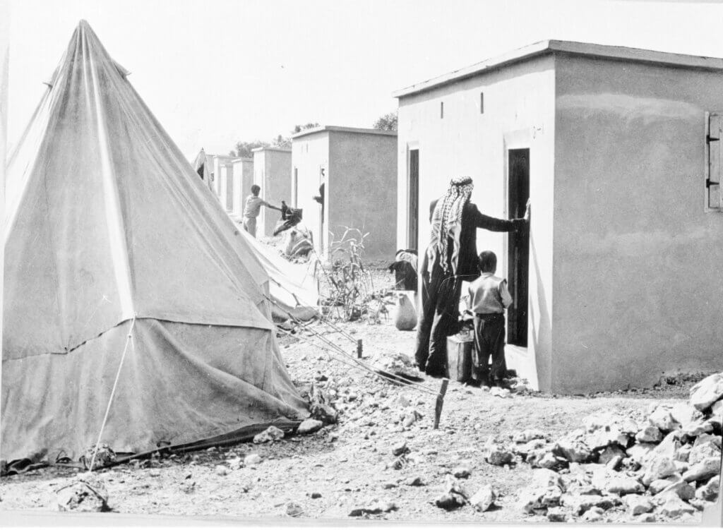 After the ninth year of living in tents since Al Nakba in 1948, 1,050 refugees from Aida refugee camp were called to a distribution centre to collect keys to their new concrete block shelters. © 1959 UNRWA Archive Jack Madvo