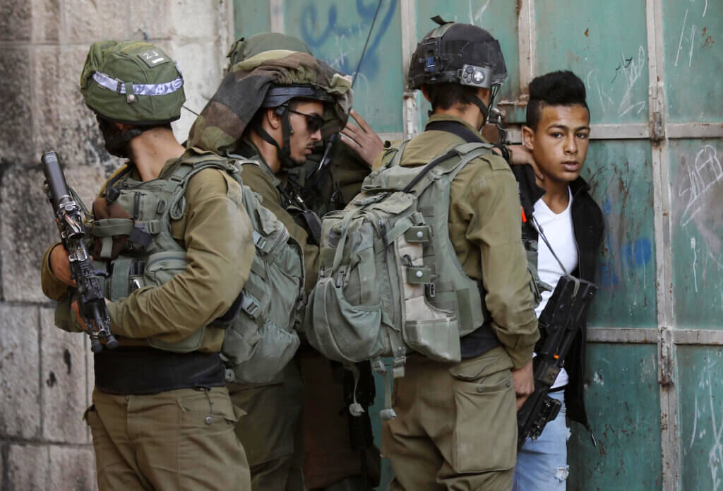 Israeli forces detain a Palestinian youth during a raid in the Old City of the West Bank city of Hebron on November 2, 2018. (Photo: Wisam Hashlamoun/APA Images)