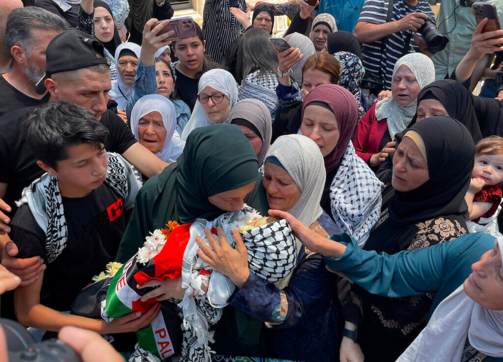 Mourners carry the body of Mohammed al-Tamimi, a two-year-old Palestinian boy shot by Israeli forces in the West Bank a week prior and who died of his wounds the previous day, during the funeral in the village of Nabi Saleh in the central part of the West Bank on June 6, 2023. (Photo: Ahmad Arouri/APA Images)