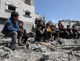 Children sit amidst the rubble of their home, which was destroyed in an Israeli airstrike in Deir al-Balah in May 2023.