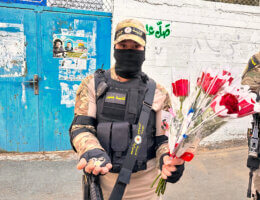 A resistance fighter from the Jenin Brigade in full military garb distributes roses on the first day of Eid al-Fitr in Jenin, April 21, 2023.