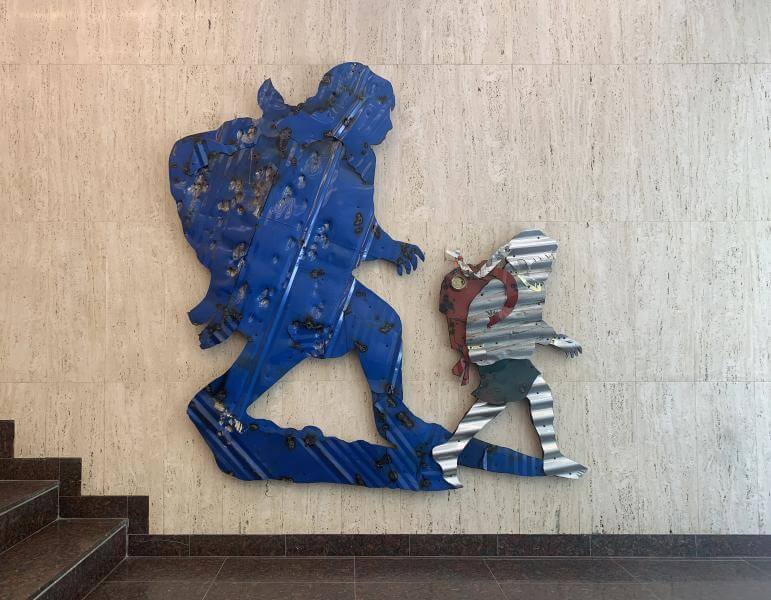Corrugates steel plates shaped into images of school children and painted over.