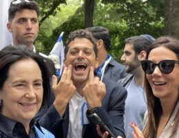 Amichai Chikli, minister of diaspora affairs in the Netanyahu government, makes an obscene gesture toward demonstrators during Celebrate Israel Parade, June 4, 2023, in New York. At left is Rebecca Caspi a vice president of the Jewish Federations. Photo from UnXeptable, a liberal Zionist organization.