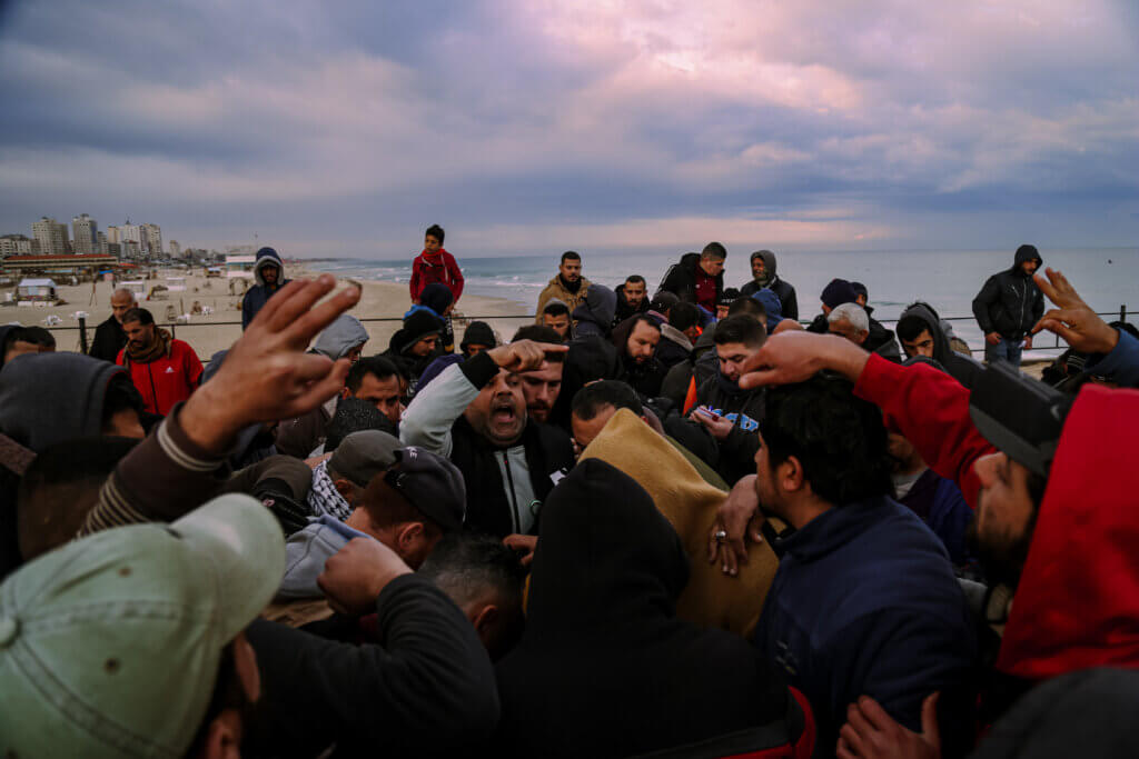 A crowds of fish sellers surround a government employee giving bids to "al-Dallal," a government employee connecting fishermen with fish-sellers.