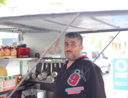 Ameen Qaddoum, 50, leans over his stall and makes tea and coffee on the street in a residential neighborhood in al-Shuja;iyya.