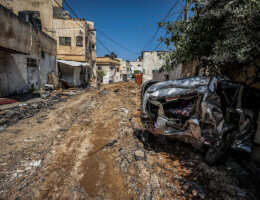 A completely decimated road in the middle of Jenin refugee camp, and to the left, a crushed car which was destroyed by an Israeli military vehicle during a raid on the camp, July 3, 2023. (Credit Image: Nasser Ishtayeh/SOPA Images via ZUMA Press Wire/APAimages)