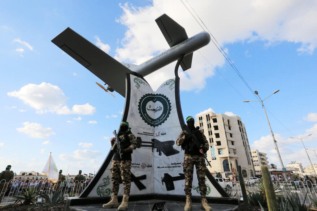 Members of the Izz al-Din al-Qassam Brigades, the military wing of Hamas, take part in the inauguration of the "Shehab" drone square in Gaza city September 21, 2022. The photo depicts two masked Qassam fighters in military uniform and sporting assault rifles posing in front of the sculpture of the "Shehad" drone.