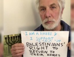 Rabbi David Mivasair holding up a sign that reads "I am a rabbi. I support Palestinians' right to return to their homes"