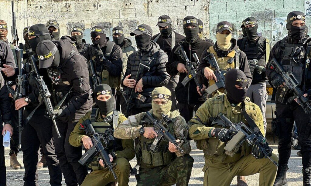 Members of the Jenin Brigade, masked and dressed in military attire and posing with weapons.