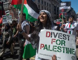 A protester holds a "Divest for Palestine" sign during a march in London, England on May 14, 2022. (Photo: Getty Images)