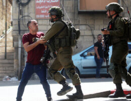 Israeli forces detain a Palestinian man following a protest in the West Bank city of Hebron on September 29, 2022. (Photo: Mamoun Wazwaz/APA Images)