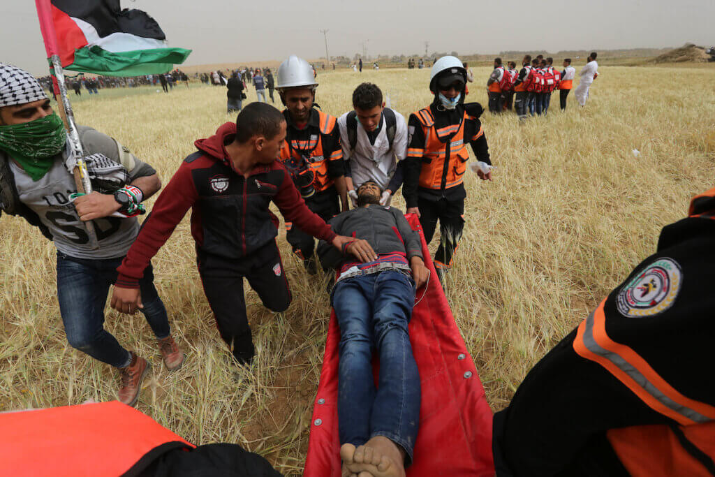 A wounded Palestinian protester is carried off on a stretcher during the Great March of Return, March 30, 2019, at the Israel-Gaza border fence near Khan Younis.