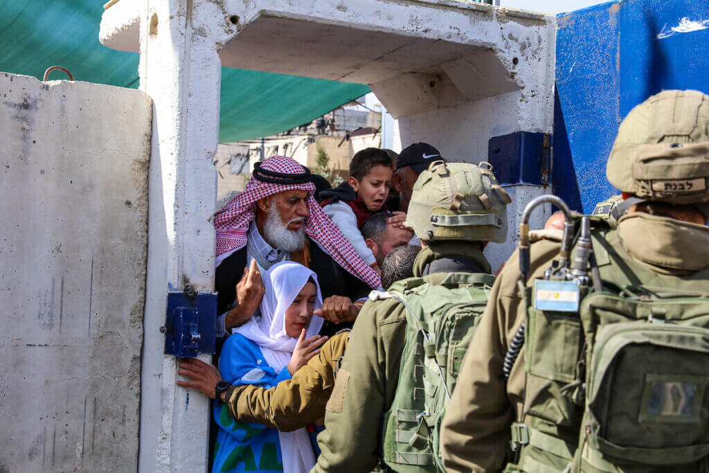 Palestinians crowding at an Israeli military checkpoint as they are stopped by Israeli soldiers and made to queue on their way to Al-Aqsa Mosque in Jerusalem.