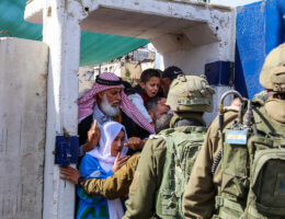 Palestinians crowding at an Israeli military checkpoint as they are stopped by Israeli soldiers and made to queue on their way to Al-Aqsa Mosque in Jerusalem.
