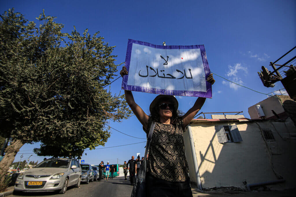 Protester holds up sign saying, "No to the occupation," as Israeli forces arrest Palestinians and solidarity activists demonstrating against Israel's illegal settlement and expulsion policies in the Sheikh Jarrah neighborhood of East Jerusalem, on September 22, 2023. (Photo: Saeed Qaq /Imago via ZUMA Press)APA images)