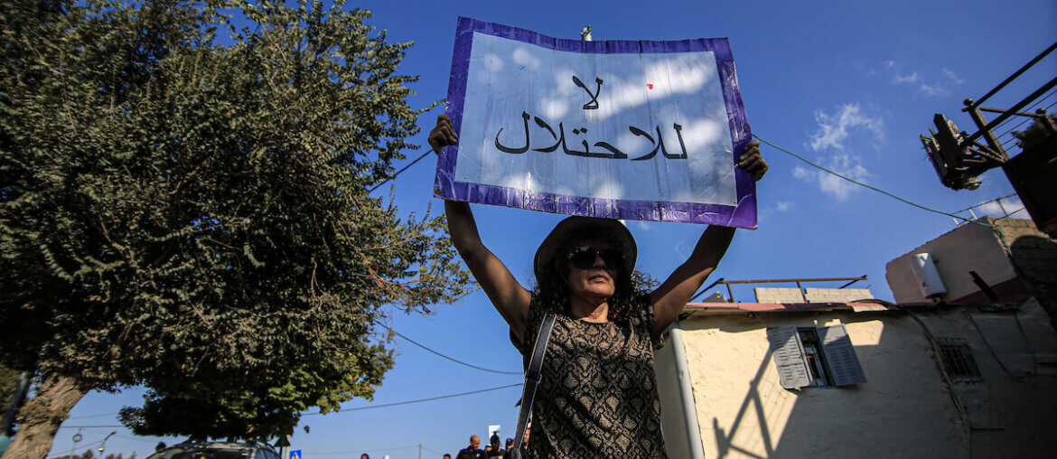 Protester holds up sign saying, "No to the occupation," as Israeli forces arrest Palestinians and solidarity activists demonstrating against Israel's illegal settlement and expulsion policies in the Sheikh Jarrah neighborhood of East Jerusalem, on September 22, 2023. (Photo: Saeed Qaq /Imago via ZUMA Press)APA images)