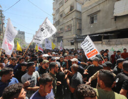 Mourners carry the body of Palestinian Majdi Ghabayen, who succumbed to wounds sustained in an explosion during a rally near the border fence with Israel on September 13, 2023. The photo is a snapshot of Ghabayen's funeral in Beit Lahia in the northern Gaza Strip on September 25, 2023, in which throngs of mourners carry his body and wave flags and banners.