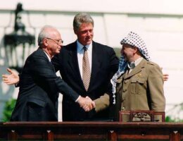 Israeli Prime Minister Yitzhak Rabin (left), U.S. president Bill Clinton (center), and PLO chairman Yasser Arafat (right), during the signing of the Oslo Accords, September 13, 1993.