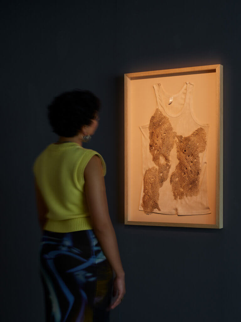 A person stands in front of an artwork in a gallery/