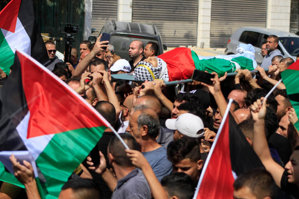 Palestinians carry the body of 19-year-old Labeeb Mohammed Dmaidi , who was shot in an overnight settler attack in the village of Huwwara, south of Nablus city, on October 6, 2023. (Photo: APA Images)