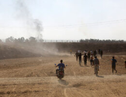 People run toward the Gaza border fence as Palestinian resistance fighters break through it on October 7, 2023.