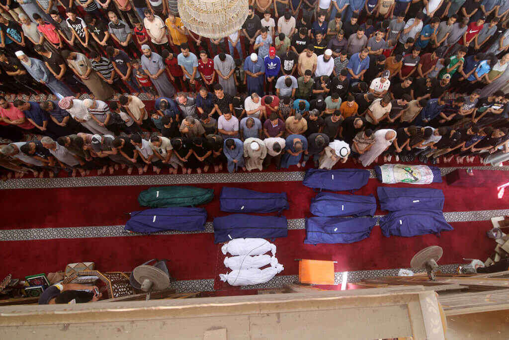People gather at a mosque to pray over the bodies of the Abu Quta family and their neighbors, killed in Israeli strikes on the Palestinian city of Rafah in the southern Gaza Strip, on October 8, 2023. (Photo: Mahmoud Fareed/APA Images)