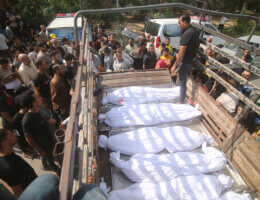 Mourners look at the covered bodies of the Abu al-Rish family, killed during an Israeli air strike in Khan Yunis, on the southern Gaza Strip on October 12, 2023. Thousands of people, both Israeli and Palestinians have died since October 7, 2023, after Palestinian Hamas militants entered Israel in a surprise attack leading Israel to declare war on Hamas in the Gaza Strip enclave on October 8.