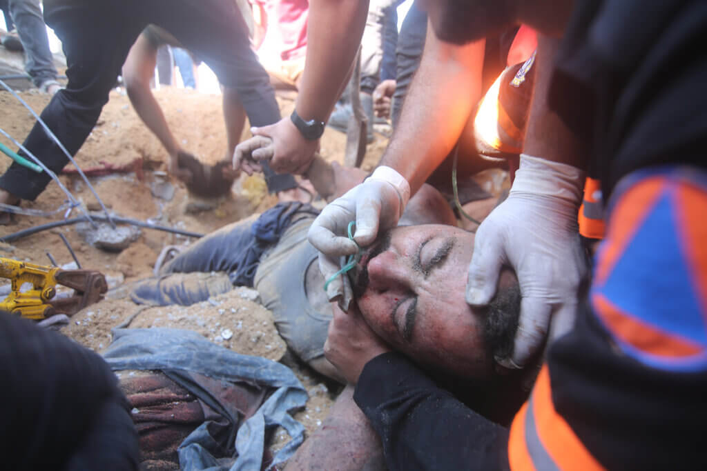 Palestinians help people injured in an Israeli air strike in Rafah in the southern Gaza Strip, on October 13, 2023. (Photo: Ahmed Tawfeq/APA Images)