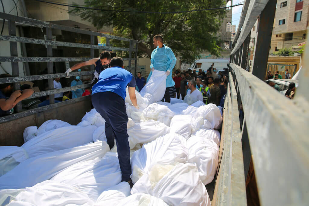 Bodies of the slain hauled onto trucks in preparation to bury them in mass graves, al-Shifa Hospital, Gaza City, October 15, 2023.