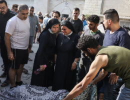 Two Palestinian nuns look down on the dead body of one of the victims of the Israeli bombing of the Greek Orthodox Church in Gaza, October 20, 2023.