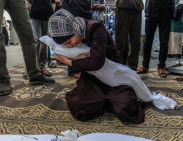 A Palestinian woman weeps as she holds the body of a child killed by Israeli airstrikes in Rafah, in the southern Gaza Strip.