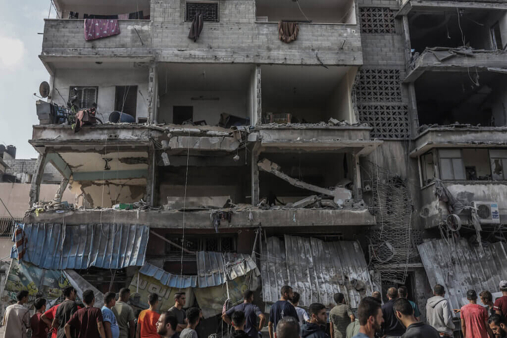 Palestinians inspect a destroyed building after an Israeli strike on Gaza City, October 24, 2023.