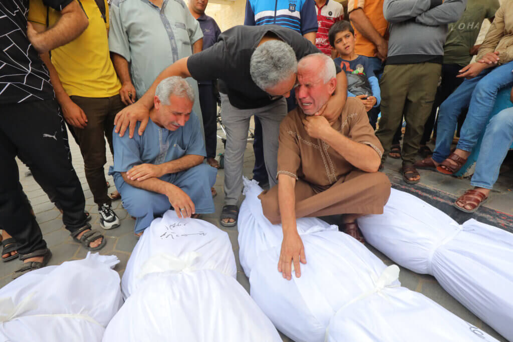 Palestinian relatives wait to collect the bodies of victims at the Al-Aqsa Hospital following an Israeli air strike on Dair El-Balah in the northern Gaza Strip. October 27, 2023.