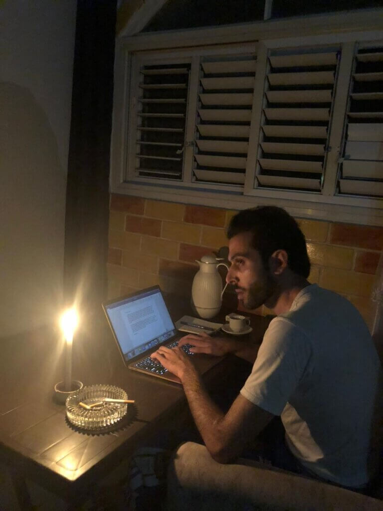 Mondoweiss Gaza Correspondent Tareq Hajjaj writing a report by candlelight during the blackout in Gaza. (Photo: Tareq Hajjaj)
