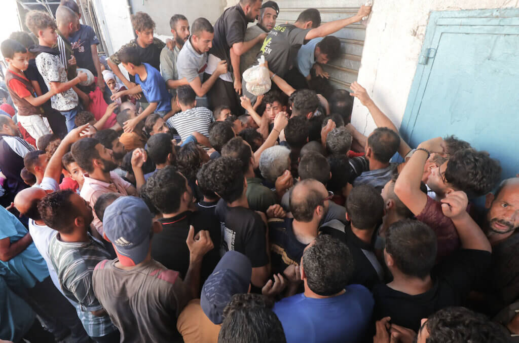 Palestinians clamor outside a bakery for bread in Nuseirat reguee camp, November 1, 2023.