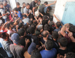 Palestinians clamor outside a bakery for bread in Nuseirat reguee camp, November 1, 2023.
